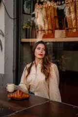 Camisa celeste de broderie con hombro y manga globo con puño.