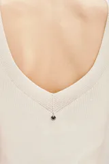 Musculosa de punto compacto, color blanco, con escote en V pronunciado y calce al cuerpo.