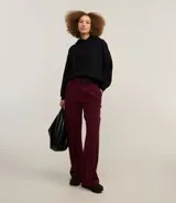 Pantalón de vestir color borgoña, de corte recto, cintura alta con medio cinturón delantero y pliegues.