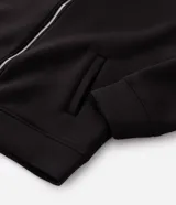 Campera bomber con capucha confeccionada en tejido técnico estructurado. Presenta cierre frontal con cremallera, bolsillos laterales y puños y cintura con elástico. Diseño versátil de corte estándar.