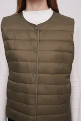 Chaleco acolchado color verde militar con cierre de botones a presión.