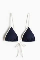 Top de bikini triangular con relleno extraíble, de color azul marino con ribetes blancos y tiras ajustables para atar en la espalda.