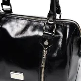 Cartera tipo baúl confeccionada en cuero negro con acabado brillante. Cuenta con dos manijas superiores, correa larga regulable y desmontable, detalles de cierres frontales verticales y herrajes metálicos plateados con el logo de la marca.