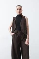 Pantalón wide leg negro de tiro alto con caída fluida y silueta amplia. Presenta cintura alta con botonadura frontal visible.