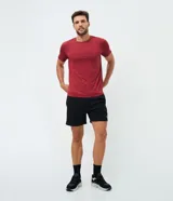 Remera deportiva de hombre en color rojo oscuro, con mangas cortas, cuello redondo y detalle de líneas negras en la manga. Confeccionada en poliéster con tecnología dry fit.
