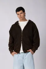 Campera oversize con capucha y cierre frontal, confeccionada en tela con acabado acid wash que le otorga un aspecto desgastado. Presenta costuras curvas decorativas en el frente y la espalda, puños y ruedo acanalados, y un calce relajado.