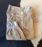 Bombacha de campo de corte tradicional, confeccionada en acrocel de algodón color beige, con detalles en tela a contratono en los laterales, puños y pretina. Cuenta con bolsillos laterales y cierre frontal con botón.