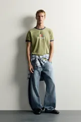 Jeans loose balloon fit de denim de algodón con diseño de cinco bolsillos y efecto lavado. Presentan bandas laterales en contraste y cierre frontal con cremallera y botón.