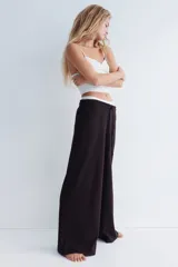 Pantalón de corte amplio confeccionado en tejido con textura tipo waffle, con cintura elástica y cordón ajustable.