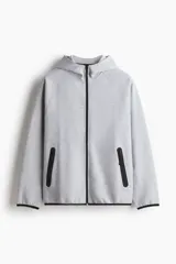 Campera deportiva de tejido funcional con efecto neopreno y tecnología DryMove para absorción de sudor. Presenta diseño de manga raglán, capucha, cierre frontal, bolsillos laterales con cierre y costuras selladas. Incluye elástico en puños y ruedo.