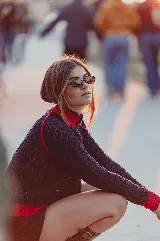 Campera tejida calada de color negro con detalles en rojo en el cuello alto, los puños, la cintura y las costuras de las mangas raglán. Cuenta con cierre frontal completo.