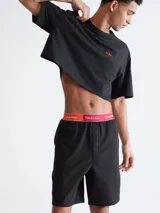 Short de dormir negro de corte relajado, largo a media pierna, con bolsillos laterales. Presenta una pretina elástica de jacquard suave en color rojo y blanco con el logo de Calvin Klein y la frase "This is Love".
