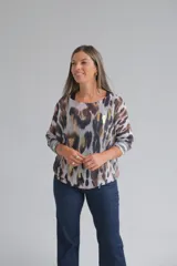 Sweater de punto con diseño animal print en tonos marrones, grises y detalles metalizados dorados. Presenta un corte holgado, cuello redondo y mangas largas con puños acanalados.