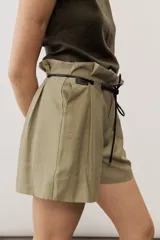 Short blanco de tiro alto, confeccionado en lino, con bolsillos laterales y cordón ajustable en la cintura.
