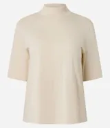 Remera negra de algodón, corte amplio, cuello alto en punto roma y mangas cortas.