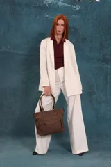 Cartera tipo tote de diseño estructurado en símil cuero, con doble asa rígida y correa regulable. Presenta múltiples bolsillos frontales con cierre y solapa, ofreciendo un estilo versátil y espacioso.