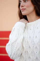 Sweater de punto con diseño de ochos, color blanco, de manga larga y cuello redondo.