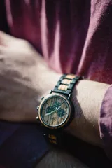 Reloj de pulsera Chenaut Aurum para hombre, con caja de acero inoxidable negra y esfera de madera de zebrano. La malla es de acero inoxidable negra con detalles en madera de bambú. Tiene cronógrafo, indicador de 24 horas y fechador.