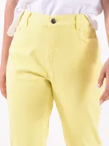 Jean de corte recto y tiro medio, color amarillo, con cierre frontal de botón y cremallera, y bolsillos laterales y traseros.