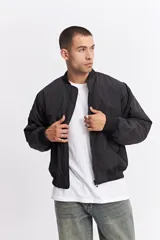 Campera tipo bomber de nylon color verde oliva, con cierre frontal, cuello, puños y cintura elastizados.