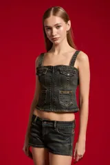 Top de jean con lavado oscuro, escote cuadrado y tirantes anchos. Cuenta con cierre frontal y múltiples bolsillos delanteros con solapa y botones.