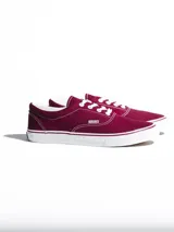 Championes de lona color azul grisáceo, estilo skate o casual, con cordones blancos y suela de goma blanca con una línea fina azul en el borde.