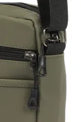 Morral color gris oscuro con correa ajustable negra. Cuenta con un compartimento principal con cierre, un bolsillo frontal con cierre y un bolsillo frontal abierto. Tiene un parche con la inscripción "NOT JUST A BAG. casual and effortless style".