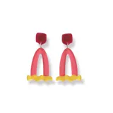 Par de aros colgantes con forma geométrica, con pieza superior cuadrada de color rojo, pieza central en forma de arco de color rosa y pieza inferior ondulada de color amarillo.