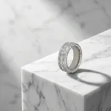 Anillo de acero con diseño de banda ancha, engastado con circonias en corte baguette y pavé en los bordes.