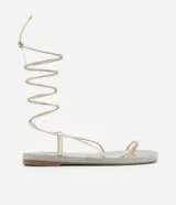 Sandalias planas doradas con tiras finas, lazo para atar al tobillo y suela forrada en cristales.