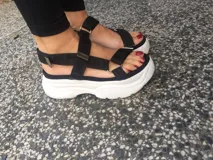 Sandalias negras con plataforma blanca y correas de velcro ajustables.