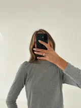 Remera gris de morley de algodón, manga larga con detalle fruncido en el hombro.