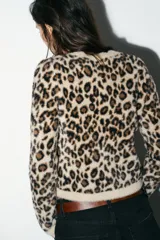 Jersey de punto con textura efecto pelo, cuello redondo y manga larga, con estampado animal print de leopardo en tonos beige, marrón y negro.