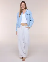Campera de denim liviano azul, de corte clásico y silueta recta, con cuello camisero, cierre frontal con botones rústicos y bolsillos con solapa en el pecho.