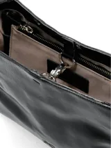 Cartera negra charol de cuero con correa regulable, abertura central con herraje metálico y división interna con cierre.