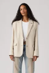 Blazer holgado color beige, de corte clásico con solapas de muesca, cierre frontal de un botón, bolsillos con solapa y mangas largas con botones en los puños.