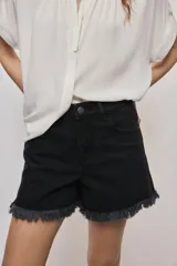 Short de jean blanco de tiro medio con silueta relajada y detalle de ruedo desflecado con flecos.