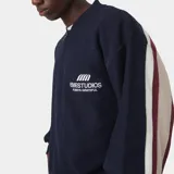 Buzo de tejido de punto con cierre frontal, diseño de franjas horizontales en azul marino, blanco y bordó, con el nombre de la marca estampado en la espalda.
