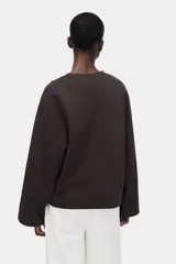 Buzo oversized de punto interlock pesado en color marrón oscuro, con cuello redondo y mangas largas amplias.