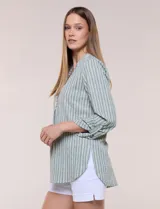 Blusa holgada de color verde con diseño de rayas verticales blancas, escote en V con cuello mao y pechera corta con botones. Mangas tres cuartos regulables y bajo redondeado.