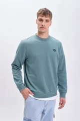 Sudadera verde de cuello redondo y manga larga, con puños y cintura acanalados. Estampado de un escorpión en el pecho.