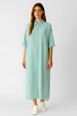 Túnica de corte holgado con diseño de rayas verticales en tonos celestes y blancos. Presenta cuello camisero, cierre frontal completo con botones y mangas cortas con dobladillo.