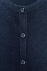 Chaqueta de punto color azul marino, con cuello redondo, manga larga y cierre frontal con botones. Los acabados son en rib a tono.