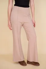 Pantalón de vestir color beige, de tela suave al tacto, con corte Oxford, cierre invisible y pinzas verticales.