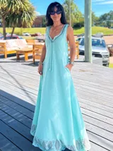 Vestido largo de algodón color celeste, con breteles finos y escote en V. Presenta un estampado geométrico en el ruedo.