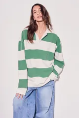 Sweater estilo polo de corte oversize, con diseño de rayas horizontales anchas en tonos camel y bordó. Presenta cuello camisero con cierre frontal parcial y mangas largas con puños ajustados.