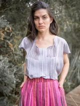 Blusa color naranja de gasa pintada con cuello asimétrico y mangas cortas.