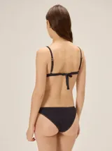 Conjunto de bikini negro de Margara, compuesto por un top de triángulo clásico y una bombacha semivedetina. Ambos presentan costuras visibles en tono contrastante y sutiles detalles de botones decorativos.