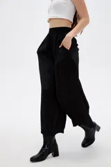 Pantalón ancho negro de poliéster, con tiro alto y cintura elástica.
