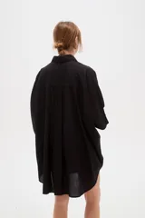 Camisa de lino blanca de corte holgado, con cuello camisero y mangas tres cuartos, diseñada con estilo casual.